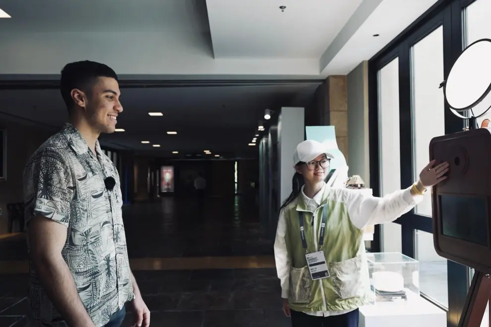 Moroccan youth Aymene engaged with the "Liangzhu Ancestors AI Face Swap Generator" at Liangzhu Museum, using artificial intelligence to create a personal portrait infused with Liangzhu cultural elements.